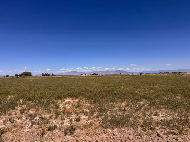 Expansive open land with distant mountain ranges under a clear sky