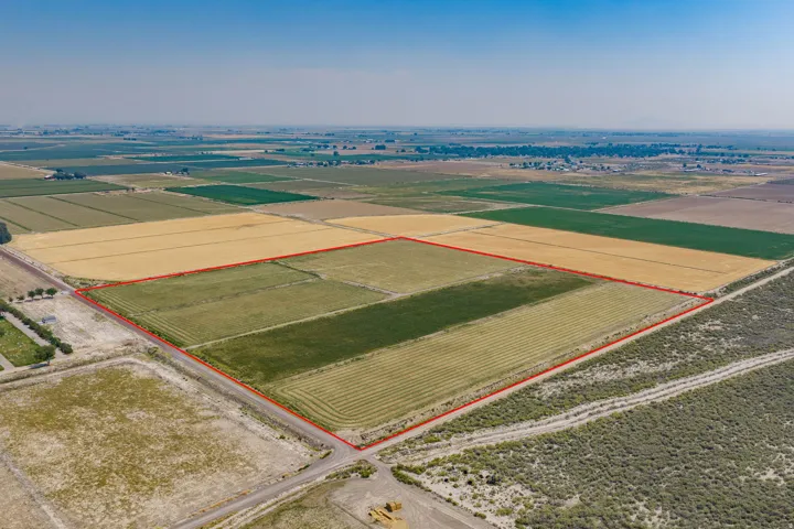 Expansive agricultural land featuring multiple cultivated fields and surrounding open terrain