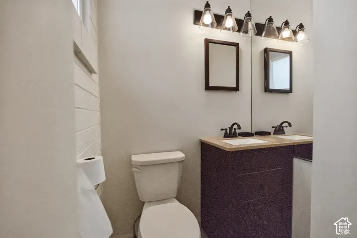 Dual vanity with undermount sinks, wood-finish cabinetry, and dark bronze fixtures