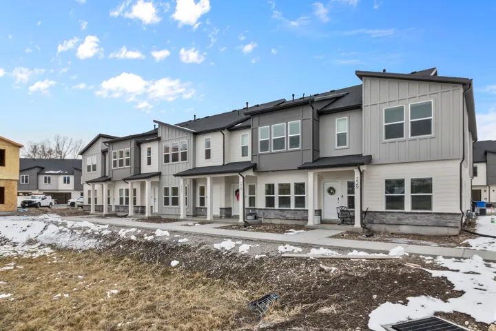 Contemporary townhomes featuring multi-tone siding, stone accents, and covered entryways