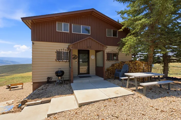 Two-story exterior with horizontal siding and upper-level vertical siding, covered entry, and gravel landscaping