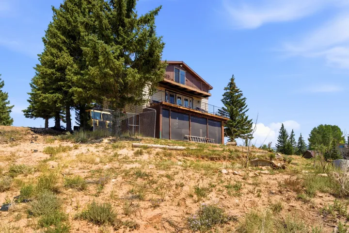 Modern multi-level residence situated on elevated terrain with expansive grounds