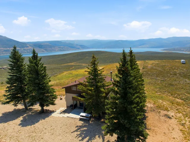 Secluded hilltop residence surrounded by mature coniferous trees and expansive grounds overlooking a pristine alpine lake