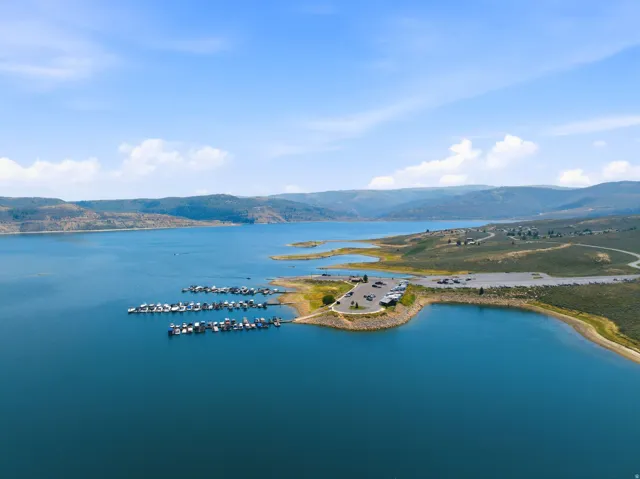 Waterfront property featuring a distinctive circular architectural structure positioned on a private peninsula, surrounded by turquoise waters and accessible deep-water mooring
