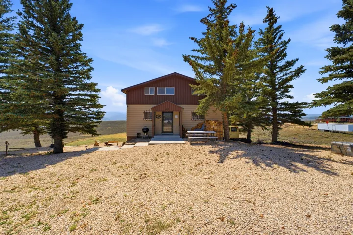 Two-story home with a two-tone exterior, front entry porch, and a gravel-covered yard