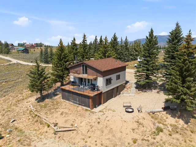 Modern mountain residence featuring a two-story design with mixed exterior materials including stone and stucco, topped with a pitched roof