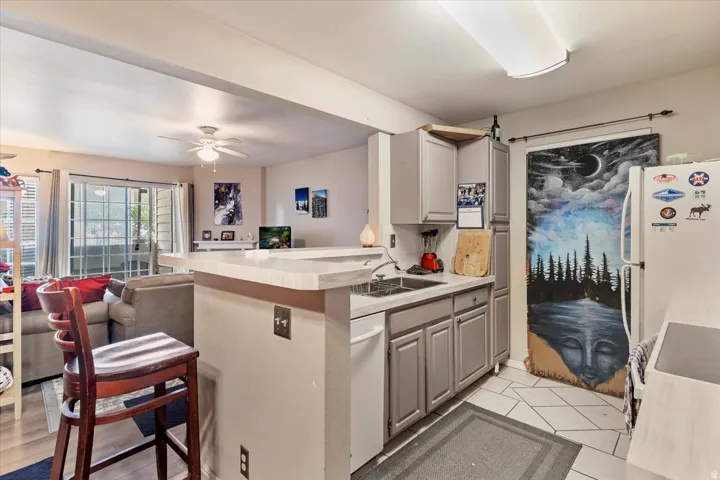 Kitchen featuring gray cabinetry, a double basin sink, and tile flooring