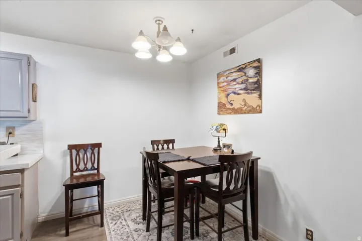 Built-in cabinetry, light-toned countertop, tile backsplash, and overhead lighting fixture