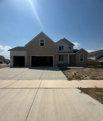 Two-story home with a light brick and siding exterior, featuring an attached two-car garage and a single-car garage