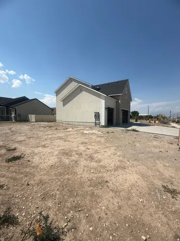Stucco exterior with brick accents, asphalt shingle roof, and a concrete driveway