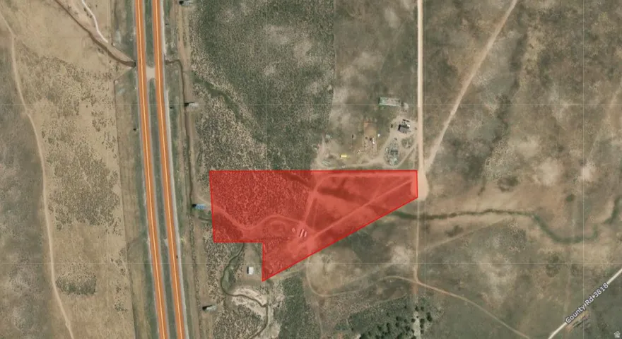 Aerial Map. Displaying the property boundaries highlighted in red, situated alongside a major roadway and adjacent to other land parcels