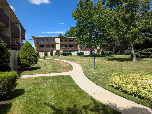 Manicured central lawn with a winding concrete pathway