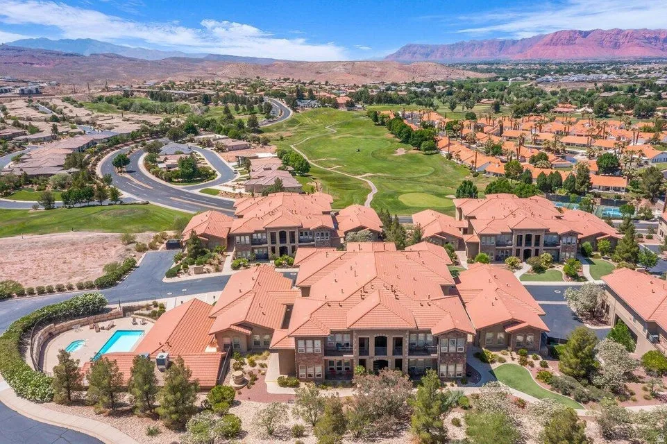 Sprawling estate featuring a terracotta tile roof, arched architectural detailing, and multiple residential pavilions set across manicured grounds