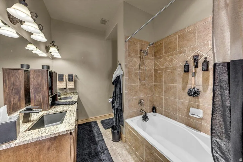 Spa-inspired master bathroom featuring dual vanities with marble-look countertops, wood-finish cabinetry, and polished nickel fixtures