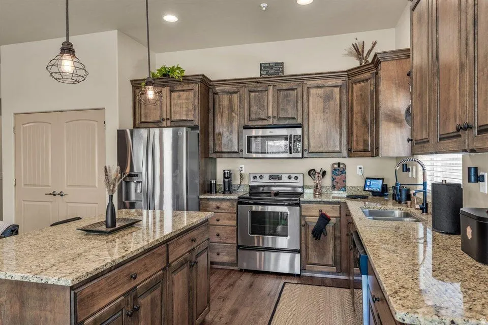 Kitchen featuring wood-finish flooring, recessed lighting, and a kitchen island with stone countertops