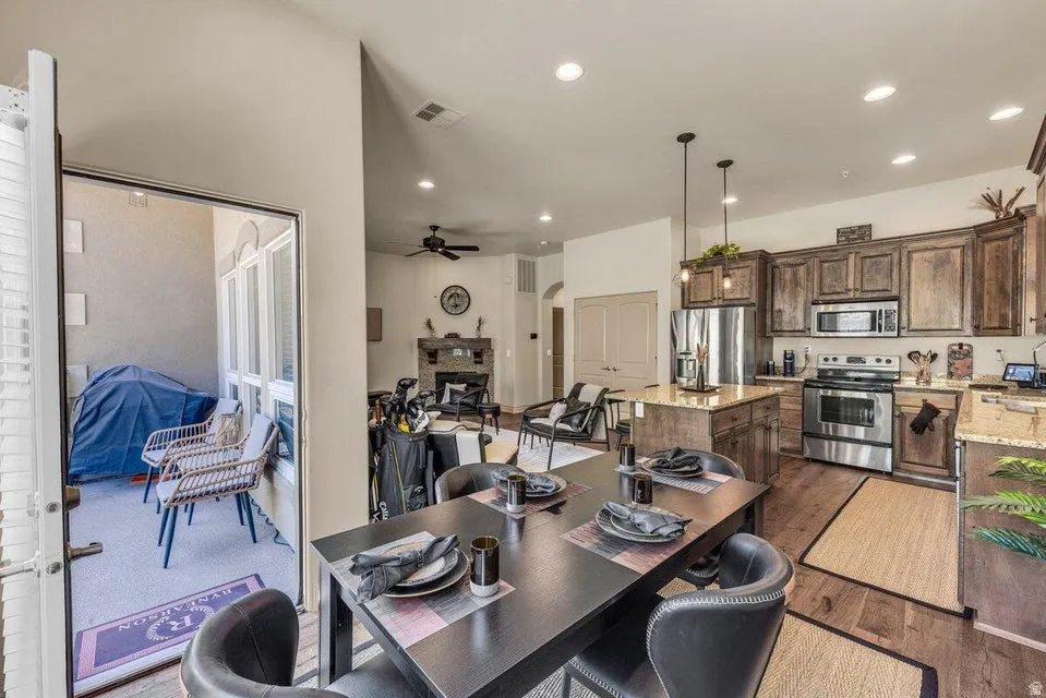 Kitchen with stainless steel appliances, wood-finish flooring, and a central island with countertop seating