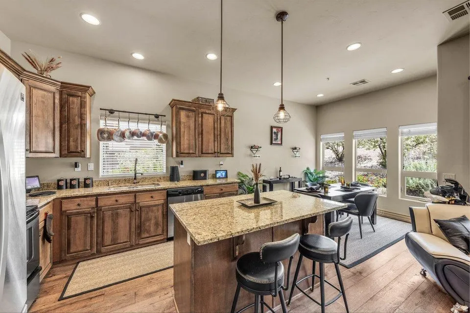 Kitchen with wood-finish flooring, recessed lighting, and a kitchen island with stone-finish countertops