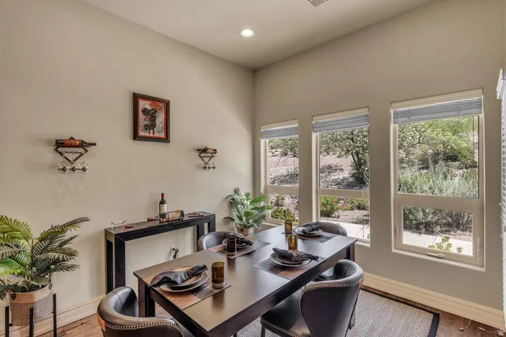 Recessed lighting, multiple windows with blinds, and wood-finish flooring