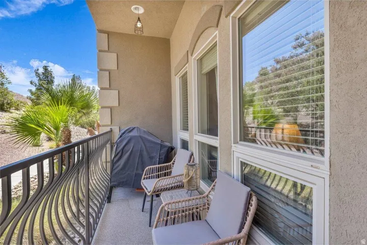 Balcony featuring decorative metal railing, stucco exterior, and multiple windows