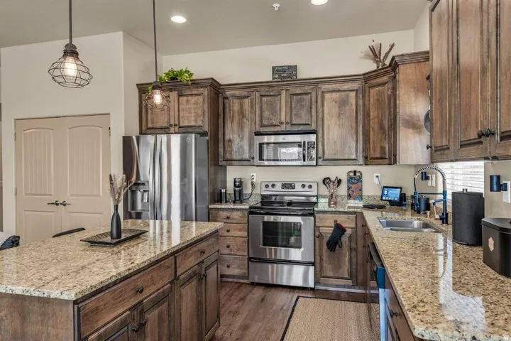 Kitchen featuring wood-finish flooring, recessed lighting, and a kitchen island with stone countertops