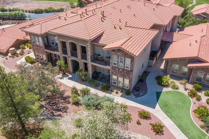 Building exterior with a terracotta-style roof, stone accents, multiple balconies, and arched entryway details