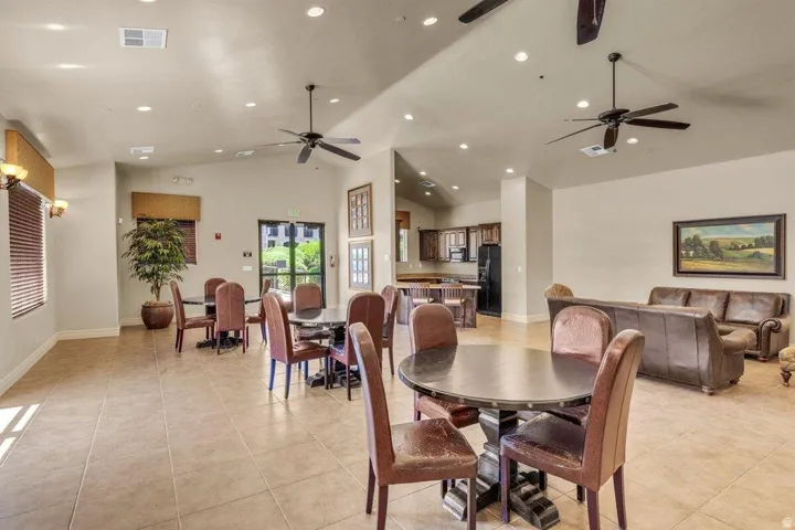 Spacious open-concept room featuring tile flooring, vaulted ceilings, recessed lighting, and ceiling fans