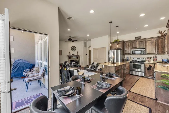 Kitchen with stainless steel appliances, wood-finish flooring, and a central island with countertop seating