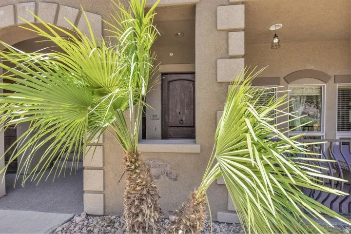 Stucco exterior with decorative stone accents and an arched entryway