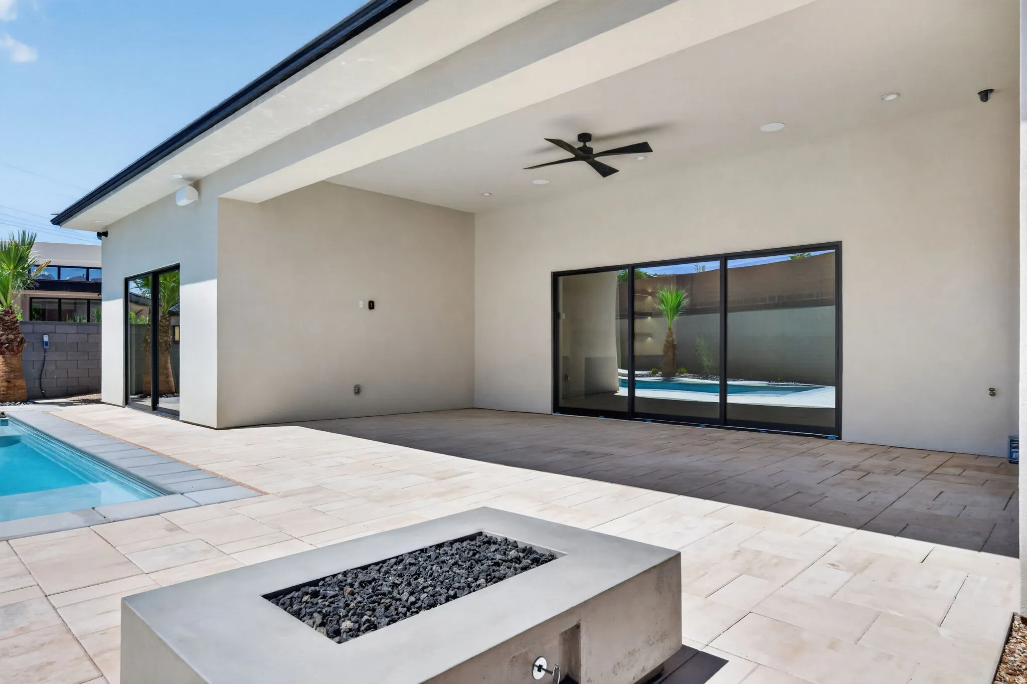 Expansive covered patio with recessed lighting, ceiling fan, and large format tile flooring