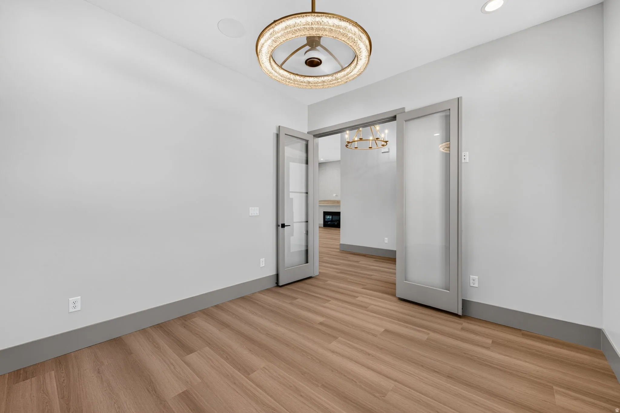 Wood-finish flooring, recessed lighting, and a modern chandelier