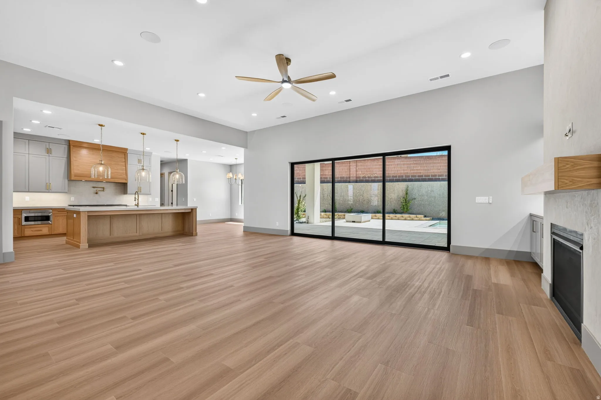 Expansive living area featuring wood-finish flooring, recessed lighting, and a ceiling fan