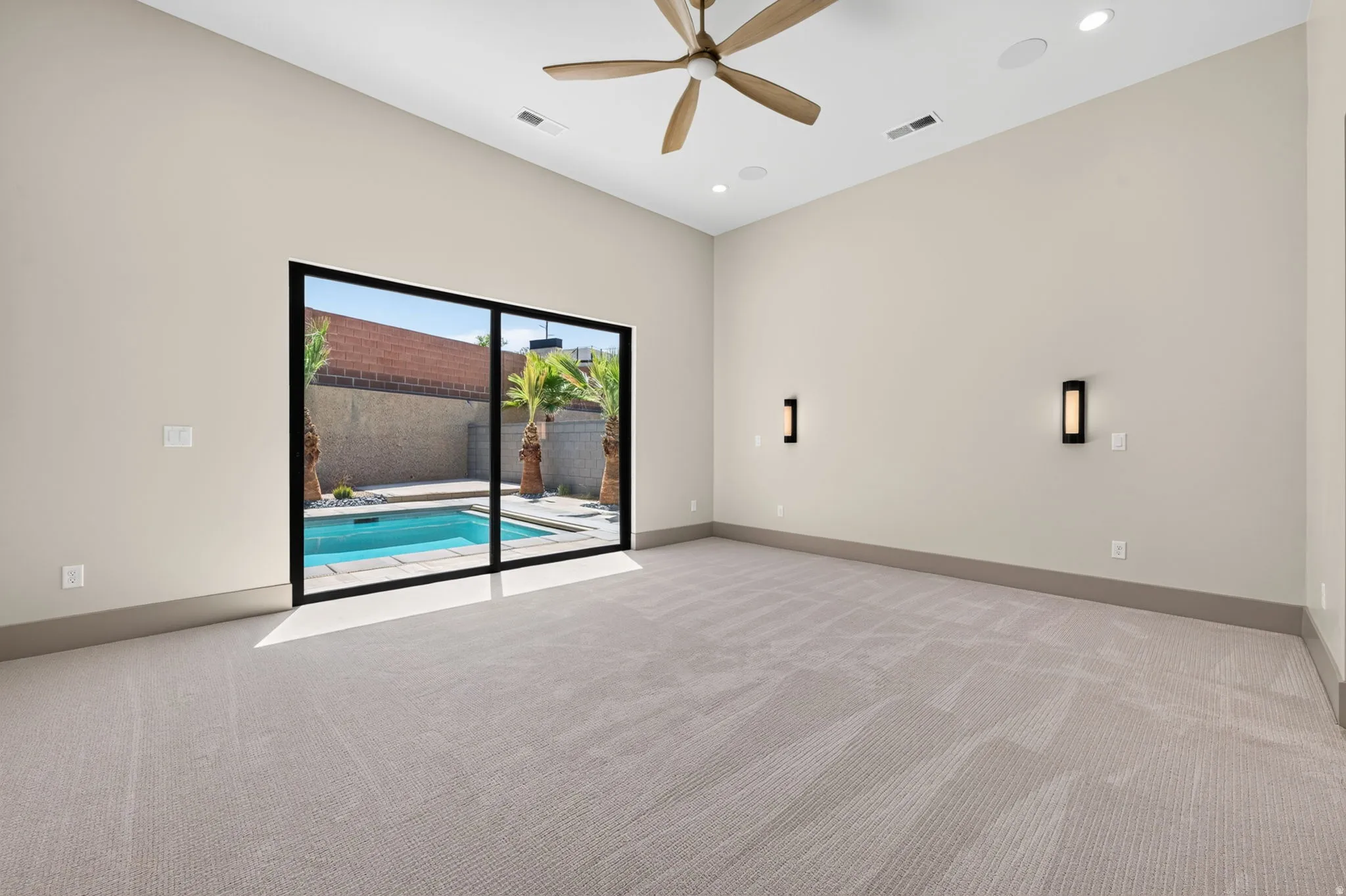 Spacious room with high ceilings, recessed lighting, and a modern ceiling fan