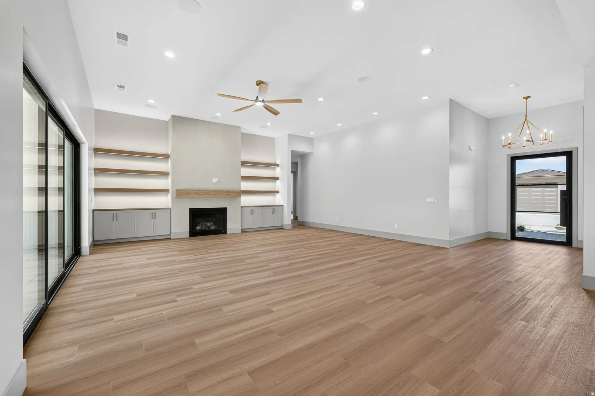 Wood-finish flooring throughout, featuring a built-in fireplace with a mantel, open shelving, and cabinet storage