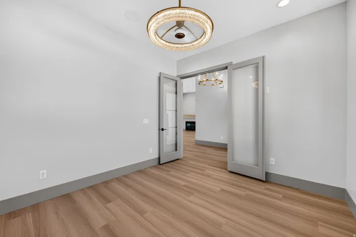 Wood-finish flooring, recessed lighting, and a modern chandelier