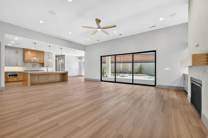 Expansive living area featuring wood-finish flooring, recessed lighting, and a ceiling fan