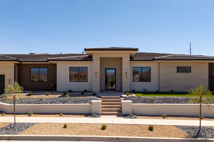 Contemporary stucco and stone exterior with dark trim windows