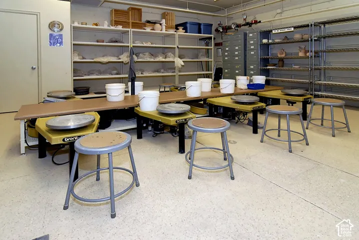 Functional laboratory or teaching space featuring multiple work stations with durable wood-finish countertops, metal frame stools with natural wood seats, and comprehensive shelving systems
