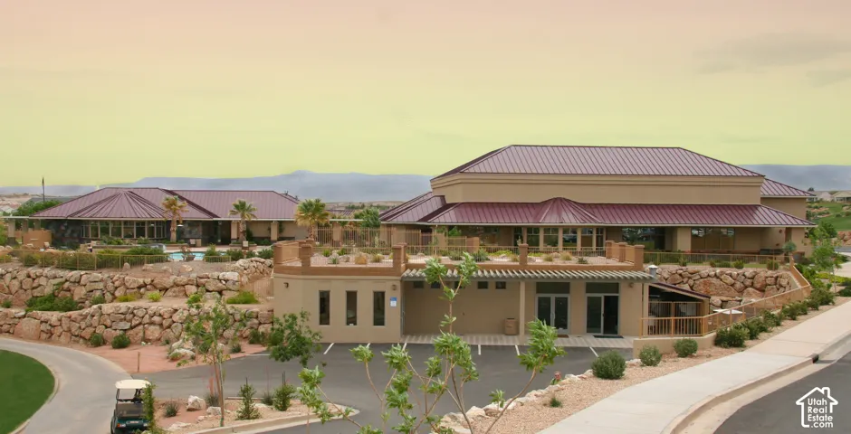 Expansive property featuring two stucco buildings with red metal roofs