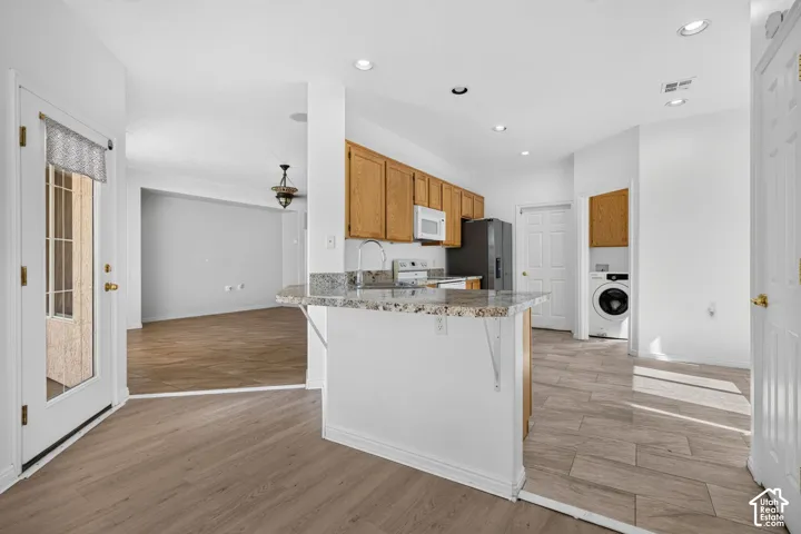 Kitchen with wood cabinetry, granite-style countertops, stainless steel appliances, and tile flooring