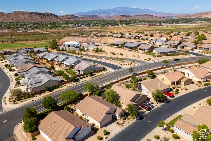 Aerial view of a residential community featuring newly constructed homes with modern architectural design, fresh asphalt driveways, and established landscaping