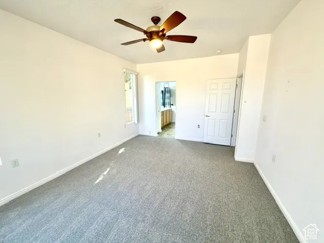 Wall-to-wall carpeting, window with natural light, ceiling fan with integrated lighting, and a paneled interior door