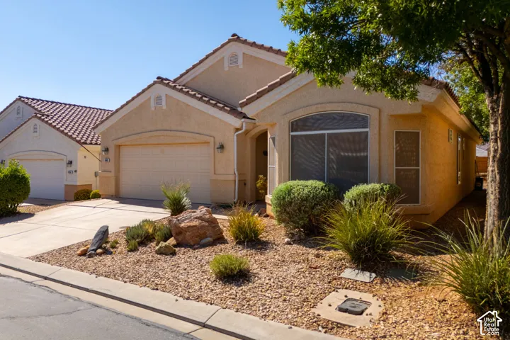 Stucco exterior with arched architectural details and tile roof accents