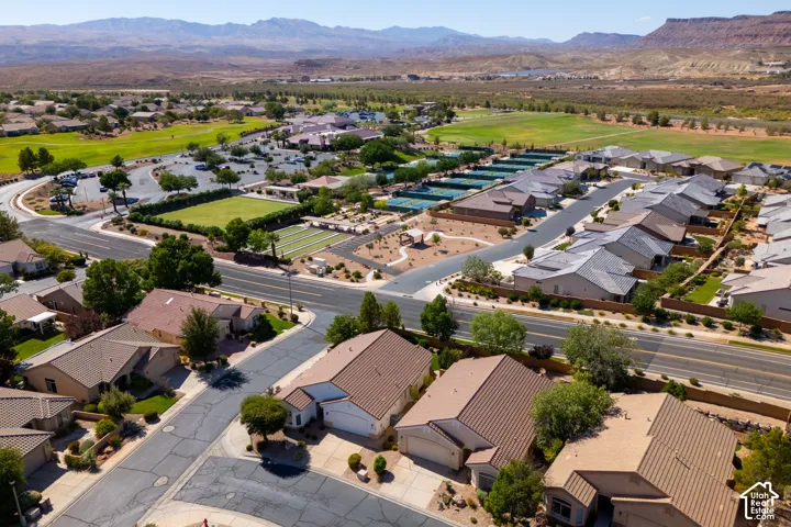 Aerial view showcasing a sprawling residential community with manicured lawns, mature landscaping, and architectural variety
