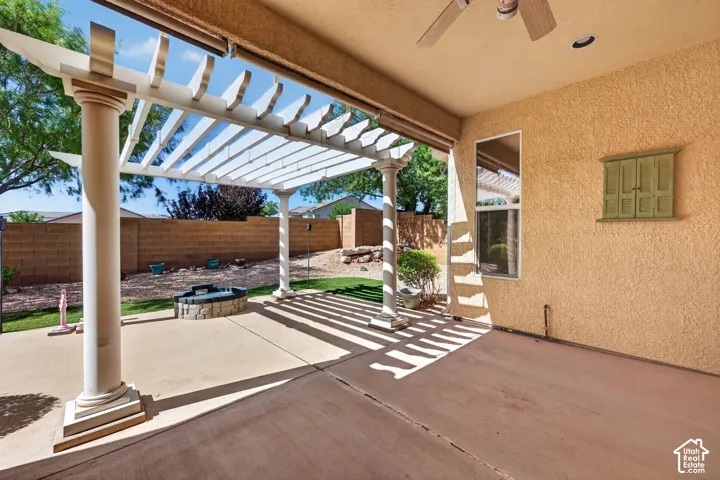 Covered patio with adjustable louvered pergola, concrete decking, and stucco exterior walls