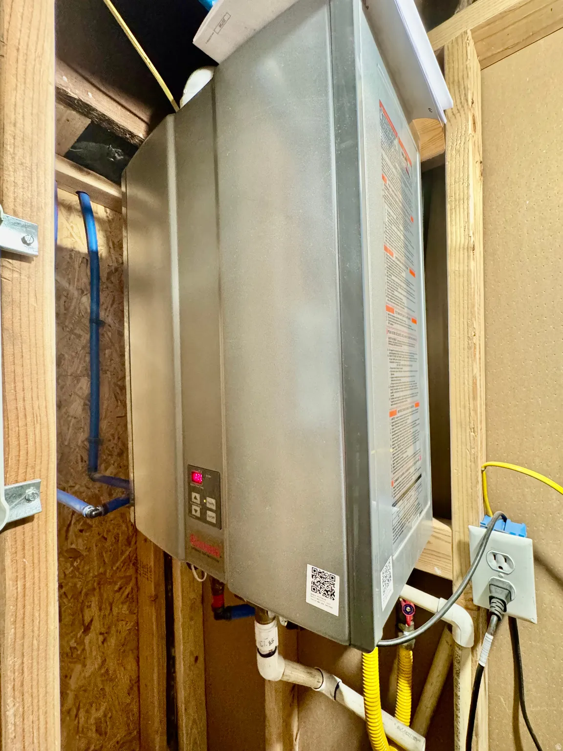 Tankless water heater installation within exposed framing