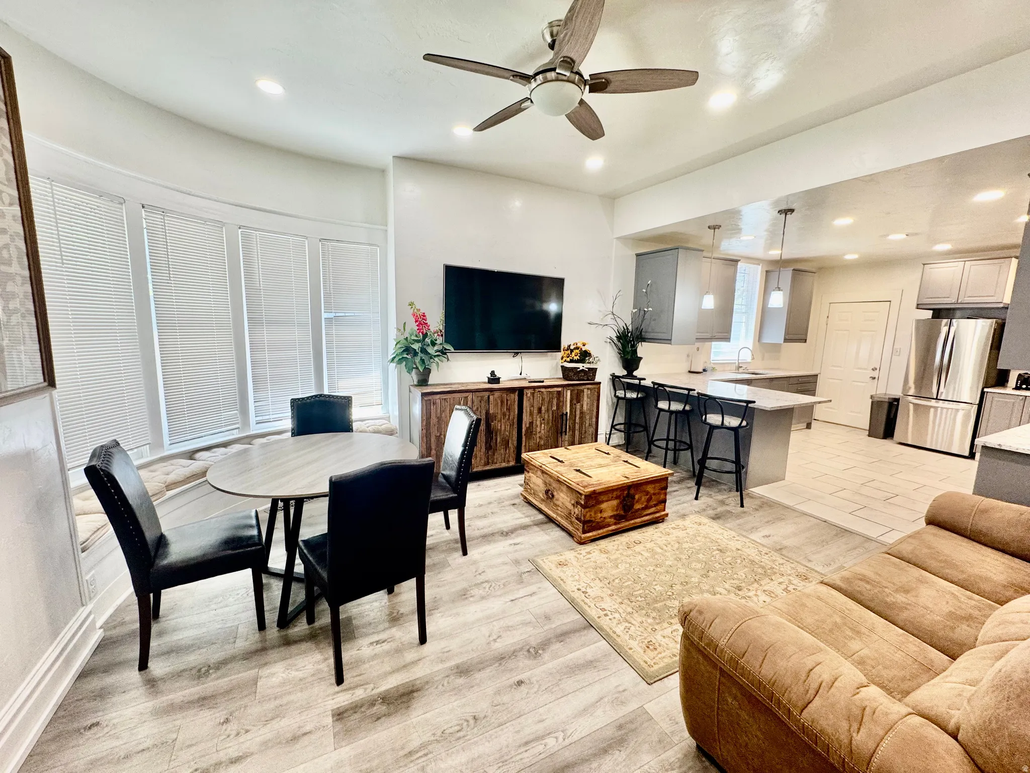 Open-concept living space featuring wood-finish flooring, recessed lighting, and a ceiling fan