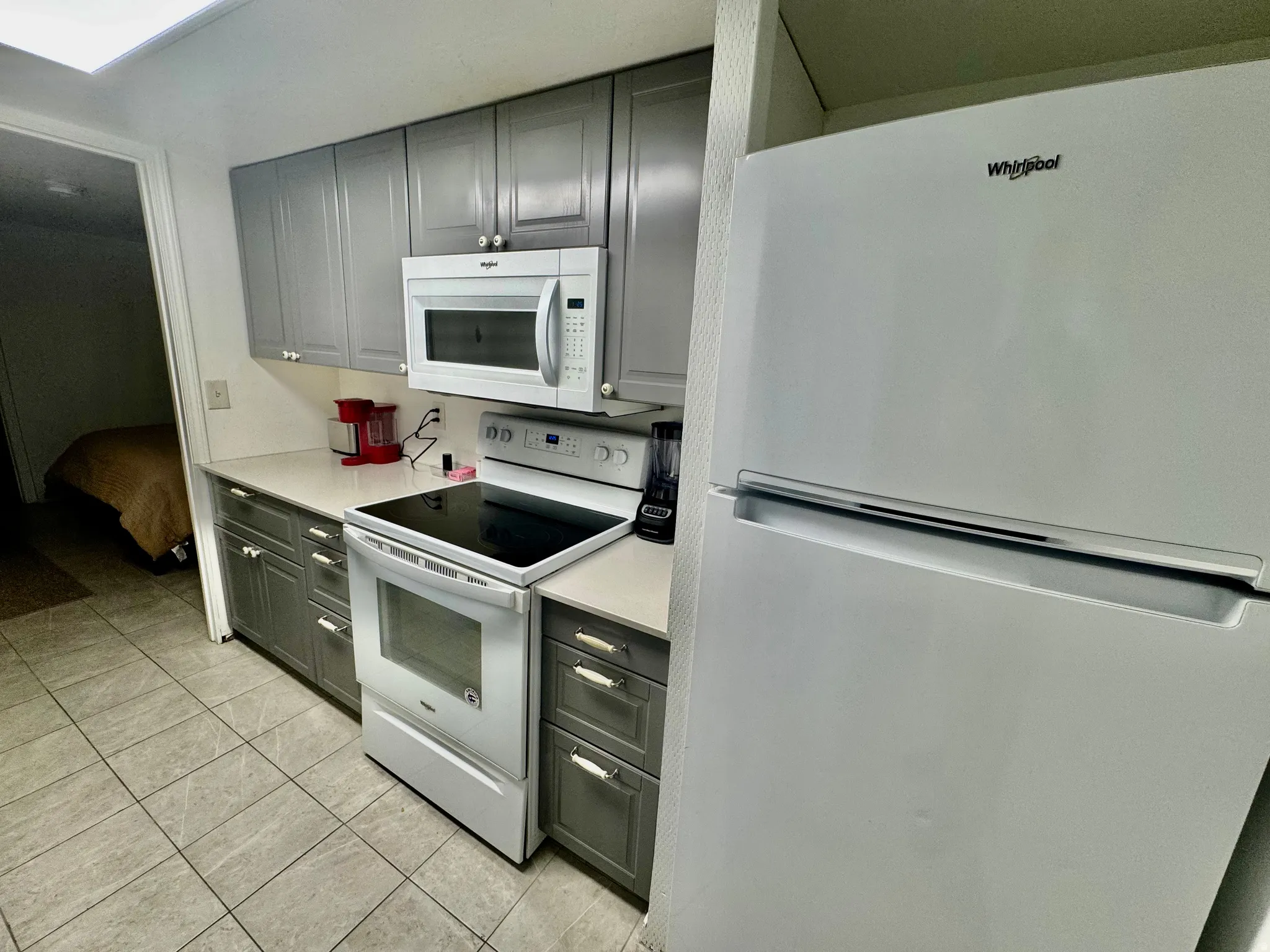 Kitchen featuring gray shaker-style cabinetry, white countertops, and tile flooring
