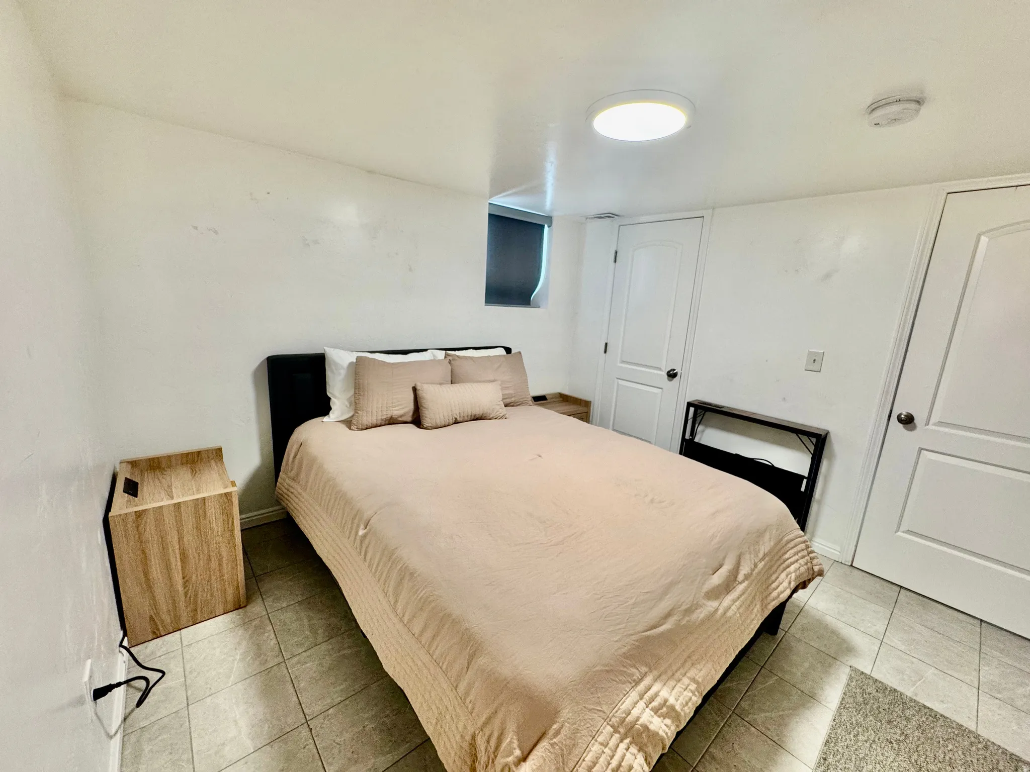 Bedroom featuring tile flooring, white walls, and a contemporary ceiling light fixture
