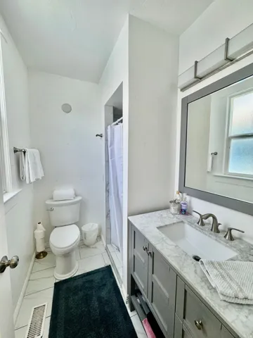 Bathroom featuring a gray vanity with a stone countertop and an undermount sink