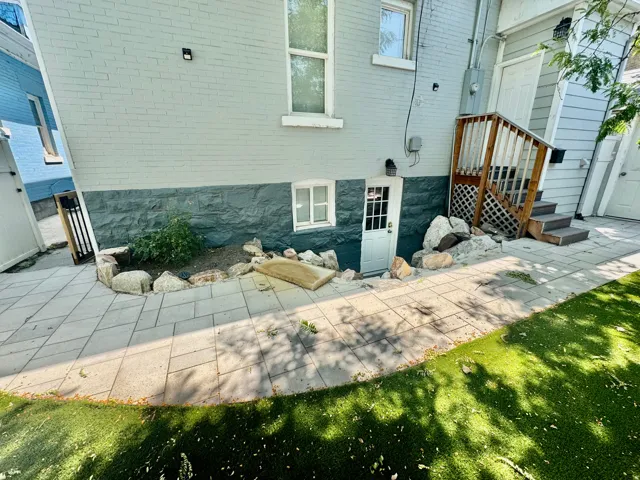 Hardscaping features a paver patio with a turf lawn border